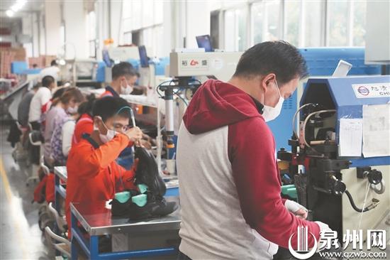 安踏员工正在车间忙碌地进行生产(文珍 摄)